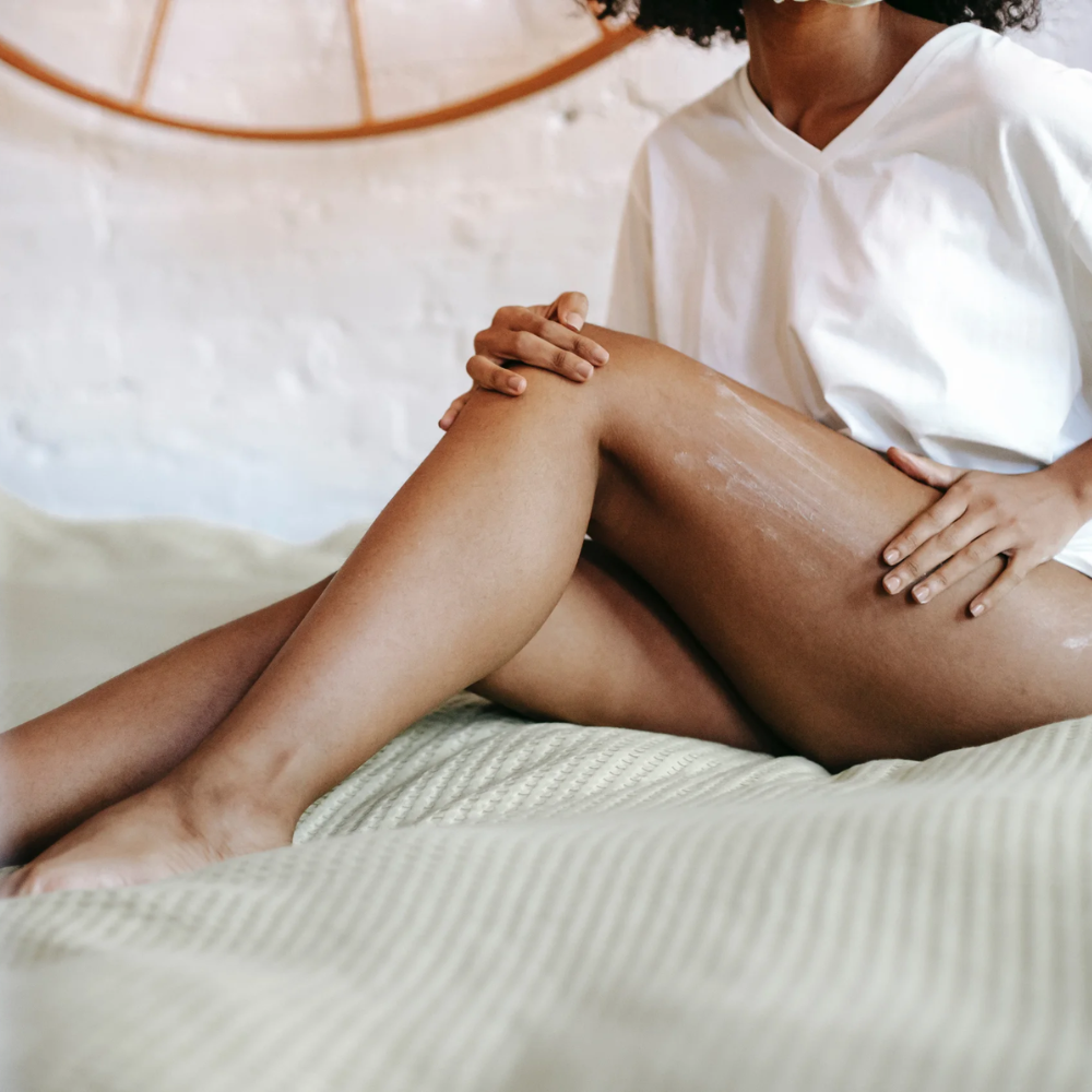 Woman applying lotion to her smooth legs